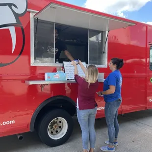 two people ordering food from a food truck