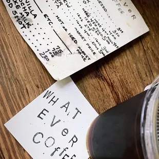 a cup of coffee and a menu on a table