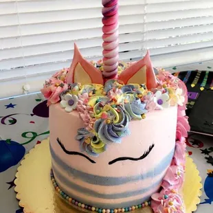 a birthday cake with a unicorn on top