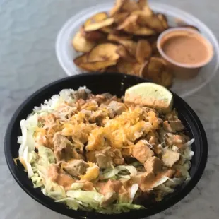 a bowl of food and a plate of chips