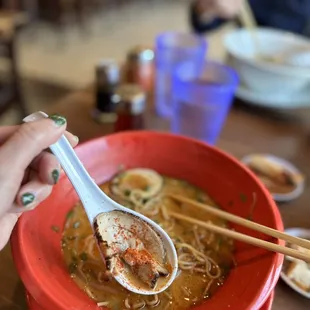 a bowl of soup with chopsticks