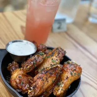 a plate of chicken wings and a drink