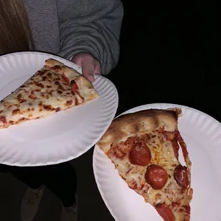 two slices of pizza on paper plates