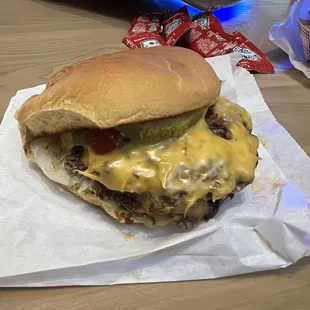 a hamburger with cheese and pickles