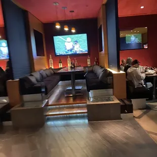 people sitting at tables and watching tvs