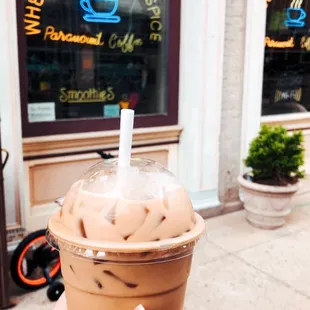 a hand holding a cup of iced coffee