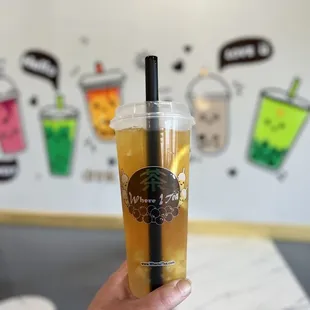 a hand holding a cup of iced tea