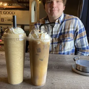 a man sitting at a table with two drinks