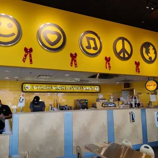 a restaurant counter with a yellow sign above it