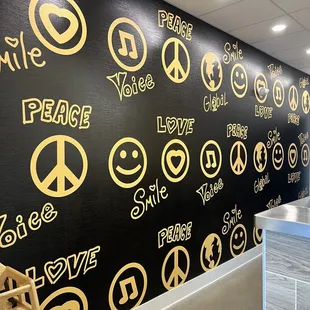 a black and gold wall with peace signs
