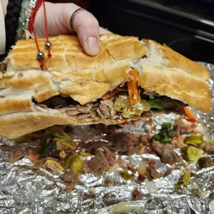 This is an Italian Beef Hoagie with Steak on a broken [super size] roll.