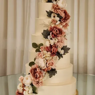 Iced smooth 6 tier cake, with a full cascade of flowers.