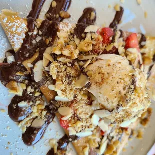 Nutella crepe with walnuts, almonds, vanilla ice cream, and a drizzle of chocolate.