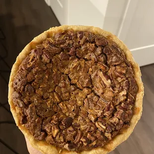a hand holding a pecan pie