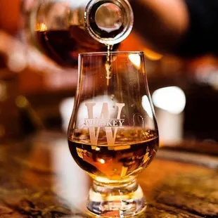 a glass of whiskey being poured