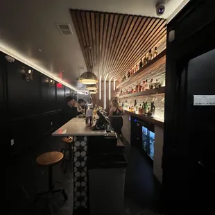 a bar with people sitting at the bar