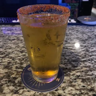 a glass of beer on a bar counter