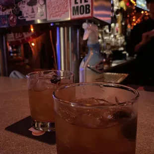 two glasses of alcohol on a bar