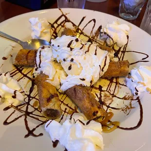 a plate of dessert with whipped cream and chocolate sauce