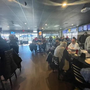 people sitting at tables and watching televisions