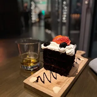 a slice of chocolate cake with whipped cream and strawberries
