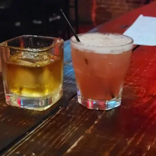 two glasses of alcohol on a wooden table