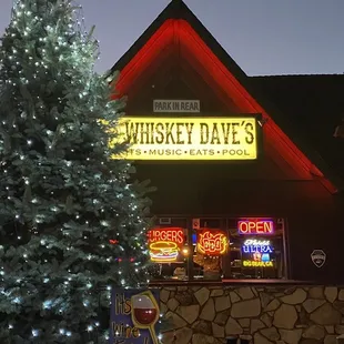 a lighted christmas tree in front of a building