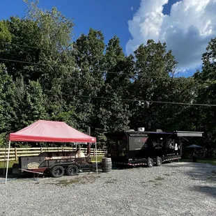 a truck and trailer parked in a gravel lot