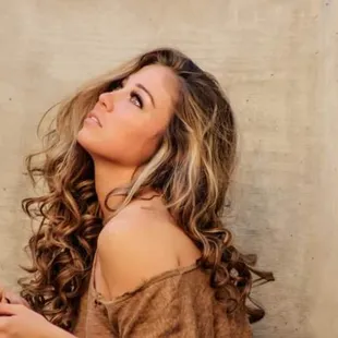 a woman leaning against a wall