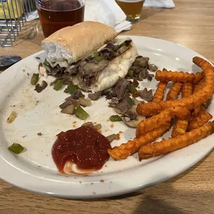 Half of the Philly sandwich snd sweet potato fries