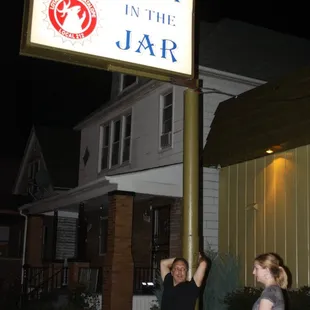 a man and a woman standing under a sign