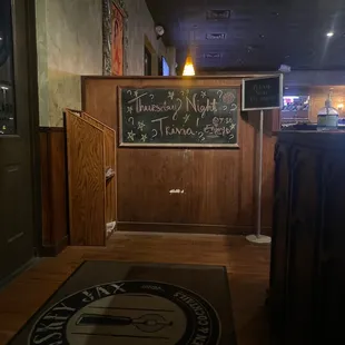 a bar with a chalkboard on the wall