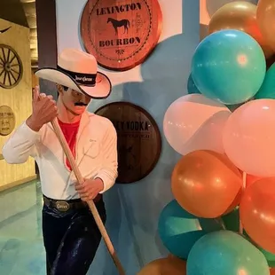 a man in a cowboy hat holding a stick