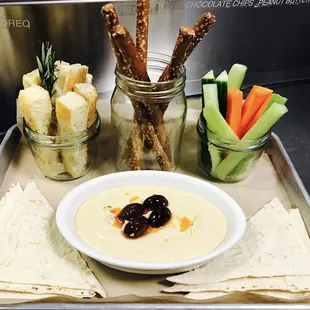 a bowl of dip with pretzels and crackers
