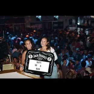 a woman holding a sign in front of a crowd