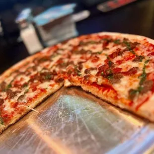 Pizza with garlic, bacon, and a pesto drizzle.