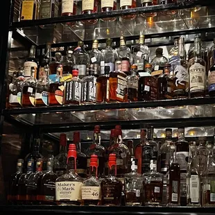 a shelf full of liquor bottles