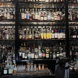 shelves of liquor bottles and liquor glasses
