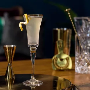 a glass of alcohol with a lemon garnish