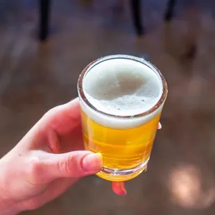 a person holding a glass of beer