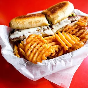 a sandwich and french fries on a red table
