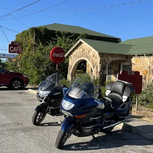 two motorcycles parked in front of a cafe