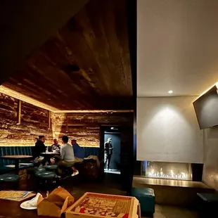 Back side of bar with more private tables and a fireplace area