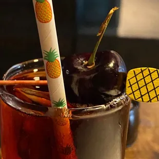 a drink with cherries and a straw