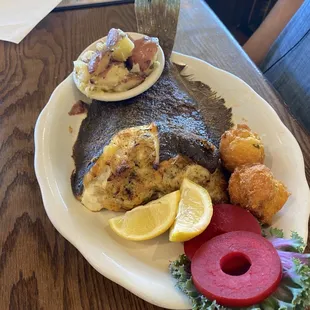 Whole Stuffed Flounder with 2 hush puppies and potatoes.