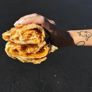 a hand holding a sandwich