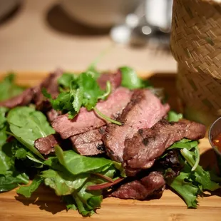 steak and greens on a cutting board