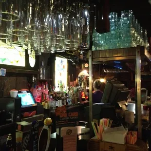 a bar with a lot of wine glasses hanging from the ceiling