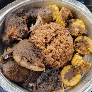 Jerk check with rice and peas and pieces of boiled corn on the cob
