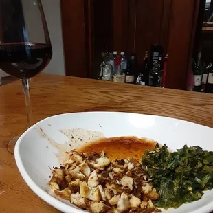 A glass of Cockburn's Special Reserve Porto and a serving of diced jerk chicken breast with island style spinach on the side.